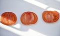 Pieces of red tomato on a white background. Chopped tomatoes