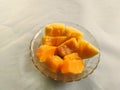 Pieces of ripe papaya in a glass bowl.