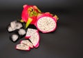 Pieces of ripe Pitaya white fruit dragon heart with ice cubes on a black background