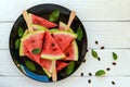 Pieces of ripe watermelon on a stick on a black plate on a white background. Royalty Free Stock Photo