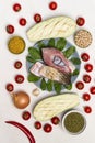 Pieces of river carp fish in plate. Eggplant, tomatoes and groats on table