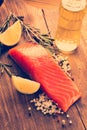 Pieces Salmon with herbs on wooden background.
