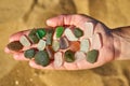 Pieces of sea glass are laid out on an open hand