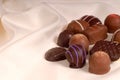 Pieces of semi-sweet and bittersweet chocolate on beige satin Royalty Free Stock Photo