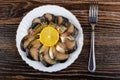 Smoked mackerel, lemon in plate, fork on wooden table. Top view Royalty Free Stock Photo