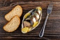 Smoked mackerel with lemon in bowl, bread, fork on table. Top view Royalty Free Stock Photo