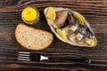 Smoked mackerel with lemon in bowl, bread, pepper shaker, fork on table. Top view Royalty Free Stock Photo