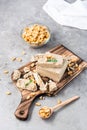 Pieces of sunflower and peanut halva and mint leaves on a cutting board and a bowl of nuts on the table. Caloric oriental dessert Royalty Free Stock Photo