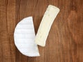 Pieces of tasty cheese camembert on a brown wooden background. Soft cheese covered with edible white mold Royalty Free Stock Photo