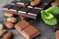 Pieces tasty chocolate and cocoa beans on table, closeup