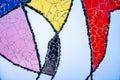 pieces of tiles of different patterns and bright colors forming abstract figures.