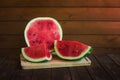 Pieces of watermelon and  half of watermelon on rustic wooden table. Selective focus Royalty Free Stock Photo