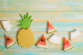 Pieces of watermelon and melon. Bright toy pineapplen on blue and yellow old wooden background. Summer concept. Flat lay, top view