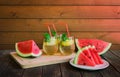 Pieces of watermelon, slices of watermelon and glasses of refreshing summer lemonade on rustic wooden table. Selective focus