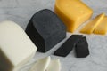 Pieces of white goat cheese, black lemon cheese and Gouda cheese