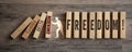 Pieces of wood with freedom day - metaphor for end of pandemic and endemic on wooden background Royalty Free Stock Photo