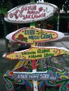 pieces of wooden boards written in Indonesian containing wise words. with a combination of color and art