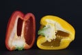 Pieces of yellow and red peppers on a black background Royalty Free Stock Photo