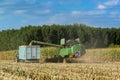 Combine harvester corn and discharge it into the trailer Royalty Free Stock Photo