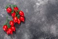 Piennolo del Vesuvio Italian heirloom tomatoes in clusters on the vine atop dark grey textured backdrop w/ copy space, top view