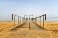 Pier on the beach over Dead Sea. Ein Bokek, Israel. Wooden path on yellow sand leaving in the distance of the dead sea. The path
