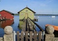 pier and boat houses on lake Ammersee with sailing boats and Alps in background in Bavarian village Schondorf (Germany) Royalty Free Stock Photo