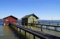 pier and boat houses on lake Ammersee with sailing boats and Alps in background in Bavarian village Schondorf (Germany) Royalty Free Stock Photo