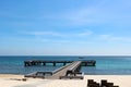 Pier for boats near a sandy beach, on a blue sea water background Royalty Free Stock Photo