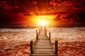 Pier for boats into the sea. Bright sunrise over the ocean. Royalty Free Stock Photo