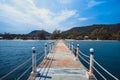 pier bridge extents from beach to turquoise wave sea. Deep Blue cloudy sky after the big storm. Expectation to success dreams, Royalty Free Stock Photo