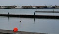 Pier on the harbor with red buoys and reflections in the water at sunset Royalty Free Stock Photo