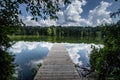 Pier on a lake with clouds reflected in the water. Located at Trap Pond State in Delaware Royalty Free Stock Photo