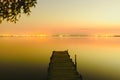 Pier on a lake at sunset with calm water and reflections of relaxing lights Royalty Free Stock Photo