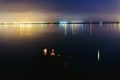 Pier on a lake at sunset with calm water and reflections of relaxing lights Royalty Free Stock Photo