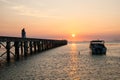 Pier landscape at sunset, people the going on a pier, happy people walking at the sea and observing a decline.