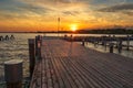 A pier leading to the lake and a red and white lighthouse on Lake Neusiedl in Podersdorf, Austria. In the background is a dramatic Royalty Free Stock Photo