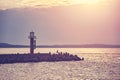 Pier with lighthouse at sunset Royalty Free Stock Photo