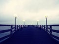 Pier at misty night with yellow lights on a background of dark blue sky Royalty Free Stock Photo