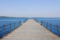 The pier near beach against blue sky in sunny day. Adriatic coast and sea in Slovenia. Holiday and travel concept Royalty Free Stock Photo