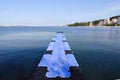 The pier near beach against blue sky in sunny day. Adriatic coast and sea in Slovenia. Holiday and travel concept Royalty Free Stock Photo