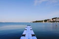 The pier near beach against blue sky in sunny day. Adriatic coast and sea in Slovenia. Holiday and travel concept Royalty Free Stock Photo