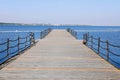 The pier near beach against blue sky in sunny day. Adriatic coast and sea in Slovenia. Holiday and travel concept Royalty Free Stock Photo