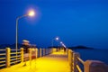 Pier at night with yellow lights on a background of blue sky Royalty Free Stock Photo