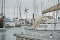 Pier with parked boats, yachts in harbor.