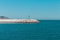 The pier of Pesaro harbor with breakwater tetrapods and a small green lighthouse Italy, Europe Royalty Free Stock Photo