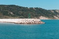 The pier of Pesaro harbor with breakwater tetrapods and a small green lighthouse Italy, Europe Royalty Free Stock Photo