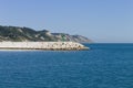 The pier of Pesaro harbor with breakwater tetrapods and a small green lighthouse Italy, Europe Royalty Free Stock Photo