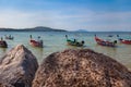 Pier Rawai beach in thailand on the island of phuket with old fishing wooden boats with long ropes moored to the shore Royalty Free Stock Photo