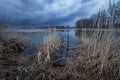 A pier in the reeds and a dark cloud over the lake Royalty Free Stock Photo