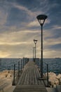 Pier on the rocky promenade by the sea at sunset. Ships on the horizon. Cyprus Royalty Free Stock Photo